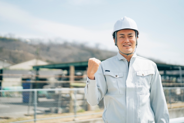 笑顔でガッツポーズをする作業員男性